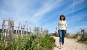 Woman happily walking barefoot on the beach