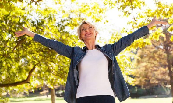 smiling happy woman with trees in the background