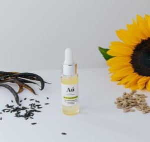 Au Anti Ageing Face Oil beside a sunflower